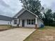 Gray vinyl-sided house with gray shingle roof, brick accents, and a paved driveway at 285 E Steele St, Salisbury, NC 28144