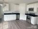 Modern kitchen with white cabinets, granite countertops, and stainless steel appliances at 285 E Steele St, Salisbury, NC 28144