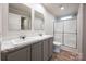 Modern bathroom with dual sinks, gray cabinets, and shower at 607 Stewart Ct, Statesville, NC 28677