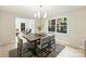 Bright dining room with wood table and gray chairs, open to living room at 7024 Pleasant Dr, Charlotte, NC 28211