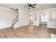 Bright living room featuring new flooring, a ceiling fan, and staircase at 10307 Taftnale Ct, Charlotte, NC 28214