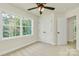 Sunlit bedroom with a ceiling fan, closet, and a wooded view from the large window at 1323 Christopher Cir, Rock Hill, SC 29730
