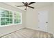 Sunlit bedroom features neutral carpet, a ceiling fan, and a large window with wooded views at 1323 Christopher Cir, Rock Hill, SC 29730