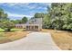 Charming home exterior featuring a covered front porch, large driveway and mature trees at 1323 Christopher Cir, Rock Hill, SC 29730