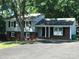 Brick ranch home with gray siding, mature trees, and a paved driveway at 1330 Bonnie Ln, Charlotte, NC 28213