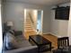 Living room with gray couch, coffee table, and view of stairs at 1330 Bonnie Ln, Charlotte, NC 28213