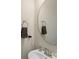 Clean bathroom with a round mirror, white sink, and gray towels at 134 Judson Ave, Charlotte, NC 28208