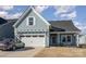 Charming light blue exterior with a two-car garage and landscaped yard at 194 Tillery Ln, Mount Gilead, NC 27306