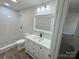 Updated bathroom with white vanity, shower, and stone-like floor at 3225 Cricketeer Dr, Charlotte, NC 28216