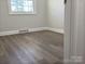 Spacious bedroom with wood-look floors and large window at 3225 Cricketeer Dr, Charlotte, NC 28216