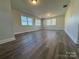 Large bedroom with neutral walls, wood-look floors, and multiple windows at 3225 Cricketeer Dr, Charlotte, NC 28216
