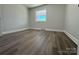 Well-lit bedroom featuring wood-look floors and a window at 3225 Cricketeer Dr, Charlotte, NC 28216