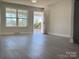 Bright living room with large windows, dark wood-look floors, and access to patio at 3225 Cricketeer Dr, Charlotte, NC 28216