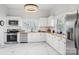 Modern kitchen with white cabinets, stainless steel appliances, and marble-look flooring at 402 N Davis Ave, Newton, NC 28658