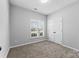 Well-lit bedroom with carpet, window, and double doors at 5809 Avian Sw Pl, Concord, NC 28025