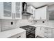 Modern kitchen with white cabinets, gas range and black range hood at 11015 Vista Haven Dr, Charlotte, NC 28226