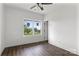 A bright bedroom featuring wood look LVP flooring, a ceiling fan, a large window, and white trim at 143 Tranquility Ln, Harmony, NC 28634
