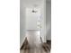 Bright hallway features continuous LVP flooring and leads to a room with a large window and ceiling fan at 143 Tranquility Ln, Harmony, NC 28634