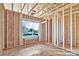 A view into the framed rooms shows a window and an open layout ready for customization and finishing touches at 143 Tranquility Ln, Harmony, NC 28634