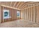 A view into a framed room reveals the studs, subfloor, and rough window openings, ready for finishing touches at 143 Tranquility Ln, Harmony, NC 28634