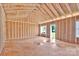 Unfinished living room shows the exposed wood framing, multiple windows, and spacious area for customization at 143 Tranquility Ln, Harmony, NC 28634