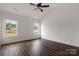 Bright bedroom featuring wood-look floors, a ceiling fan, and natural light from two windows at 149 Tranquility Ln, Harmony, NC 28634
