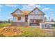 A framed two-story home featuring a covered porch and visible garage opening at 149 Tranquility Ln, Harmony, NC 28634