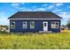 Beautiful, newly constructed home with dark-blue exterior siding, white door, and new windows at 149 Tranquility Ln, Harmony, NC 28634
