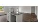 Kitchen island with granite countertops and white cabinets featuring wood-look flooring at 149 Tranquility Ln, Harmony, NC 28634