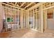 The living room area features a wall frame, pink insulation, and windows overlooking the backyard at 149 Tranquility Ln, Harmony, NC 28634