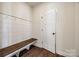 Mudroom boasts a wooden bench, coat hooks, and wood-look floors for added functionality at 18011 Wilbanks Rd, Charlotte, NC 28278