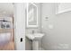 Modern bathroom with pedestal sink and illuminated mirror at 1927 W Trade St, Charlotte, NC 28216