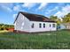 Side view of a newly constructed home featuring white siding, a dark roof, and windows under a bright sky at 244 Little Wilkesboro Rd, Harmony, NC 28634