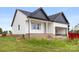 Charming exterior view of the home featuring white siding, black roof, covered porch, and an attached garage at 244 Little Wilkesboro Rd, Harmony, NC 28634