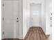 Bright hallway with modern flooring, connecting to other rooms and featuring a front door with glass panels for natural light at 244 Little Wilkesboro Rd, Harmony, NC 28634