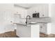 Close-up view of the kitchen with an island featuring granite countertops, white cabinetry, and a subway tile backsplash at 244 Little Wilkesboro Rd, Harmony, NC 28634