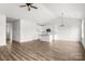 Bright living room featuring hardwood floors, a modern ceiling fan, and a stylish kitchen with white cabinets at 244 Little Wilkesboro Rd, Harmony, NC 28634