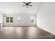 Open floor plan of a home's living room with hardwood floors and windows offering backyard views at 244 Little Wilkesboro Rd, Harmony, NC 28634