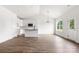 Open living room with hardwood floors, white walls, a modern kitchen, and a large window providing natural light at 244 Little Wilkesboro Rd, Harmony, NC 28634