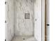 Bright shower stall boasts marble tile walls, mosaic tile floor, and sleek shower fixtures at 244 Little Wilkesboro Rd, Harmony, NC 28634