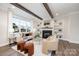 Spacious living room with hardwood floors, fireplace, built-in shelving, and large windows at 4006 Avalon Ave, Charlotte, NC 28208