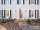 Front entrance with red door, brick steps, and planters at 410 Lakenheath Ln, Matthews, NC 28105