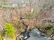 An aerial view shows a lakeside boathouse and private dock with a walkway through the trees at 412 Wildlife Rd, Troutman, NC 28166