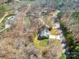 Aerial view of the home surrounded by trees, a well-manicured lawn, and on a lake at 412 Wildlife Rd, Troutman, NC 28166