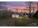 Charming home with a two-car garage, manicured lawn, and inviting front porch at twilight at 412 Wildlife Rd, Troutman, NC 28166