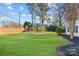 Landscaped backyard with green lawn and trees at 5204 Sardis Rd, Charlotte, NC 28270