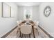 Bright dining room features a wood table, six chairs, neutral rug, and stylish decor at 8024 Kennesaw Dr, Gastonia, NC 28056