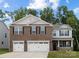 Beautiful two-story home featuring a brick and siding facade with a two car garage and manicured lawn at 8024 Kennesaw Dr, Gastonia, NC 28056
