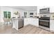 Bright, open kitchen with stainless steel appliances, white cabinetry, and wood-look flooring at 8024 Kennesaw Dr, Gastonia, NC 28056