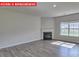 Living room with corner fireplace and large windows at 8024 Kennesaw Dr, Gastonia, NC 28056